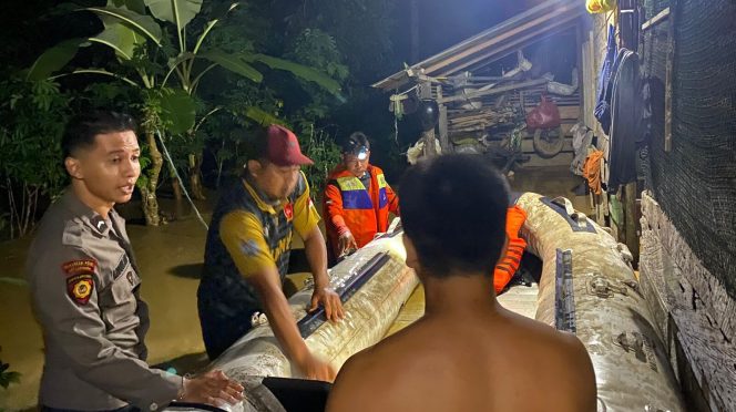 
					Polisi dan Pemerintah Desa evakuasi warga yang terdampak banjir di Karangan. 