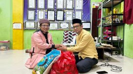 Ketua PWI Bontang Kusnadi (kanan) saat menyerahkan bantuan sembako kepada pimpinan pondok pesantren, Ustadz Khumaini Rosadi. (PWI Bontang)