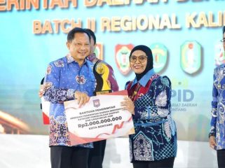 Menteri Dalam Negeri Tito Karnavian (kiri), menyerahkan penghargaan terbaik I kategori Pemerintah Daerah Pengelolaan Sampah dan Lingkungan Asri kepada Wali Kota Bontang, Kalimantan Timur Neni Moerniaeni (Foto: Dok. Prokompim Kota Bontang)