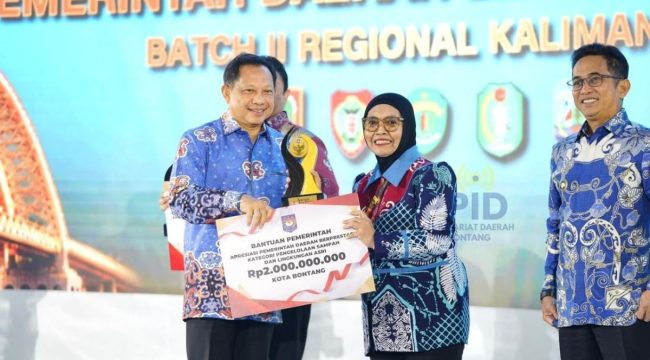 Menteri Dalam Negeri Tito Karnavian (kiri), menyerahkan penghargaan terbaik I kategori Pemerintah Daerah Pengelolaan Sampah dan Lingkungan Asri kepada Wali Kota Bontang, Kalimantan Timur Neni Moerniaeni (Foto: Dok. Prokompim Kota Bontang)